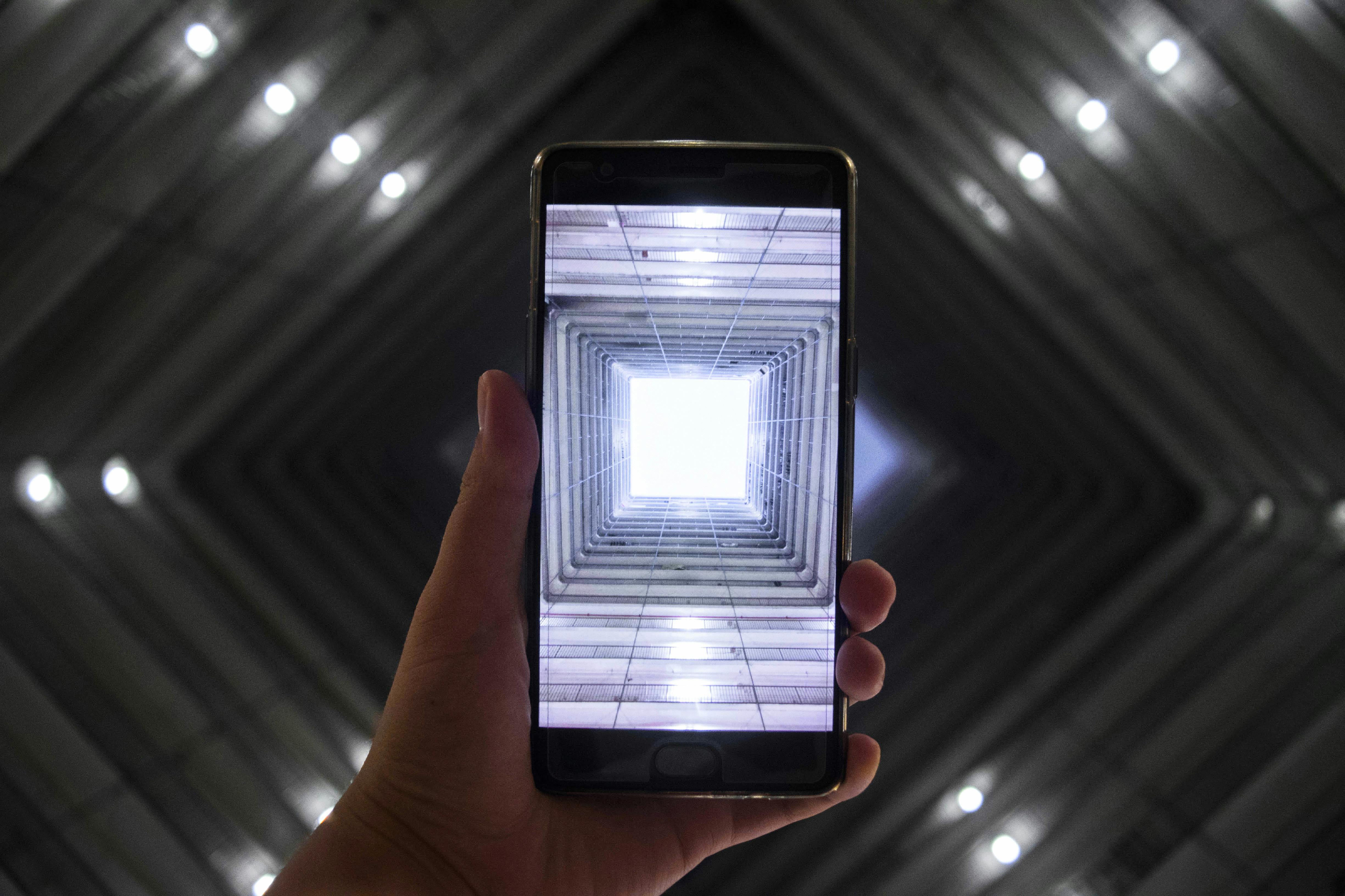 智能手机捕捉到建筑内部对称照明的画面，凸显了现代技术