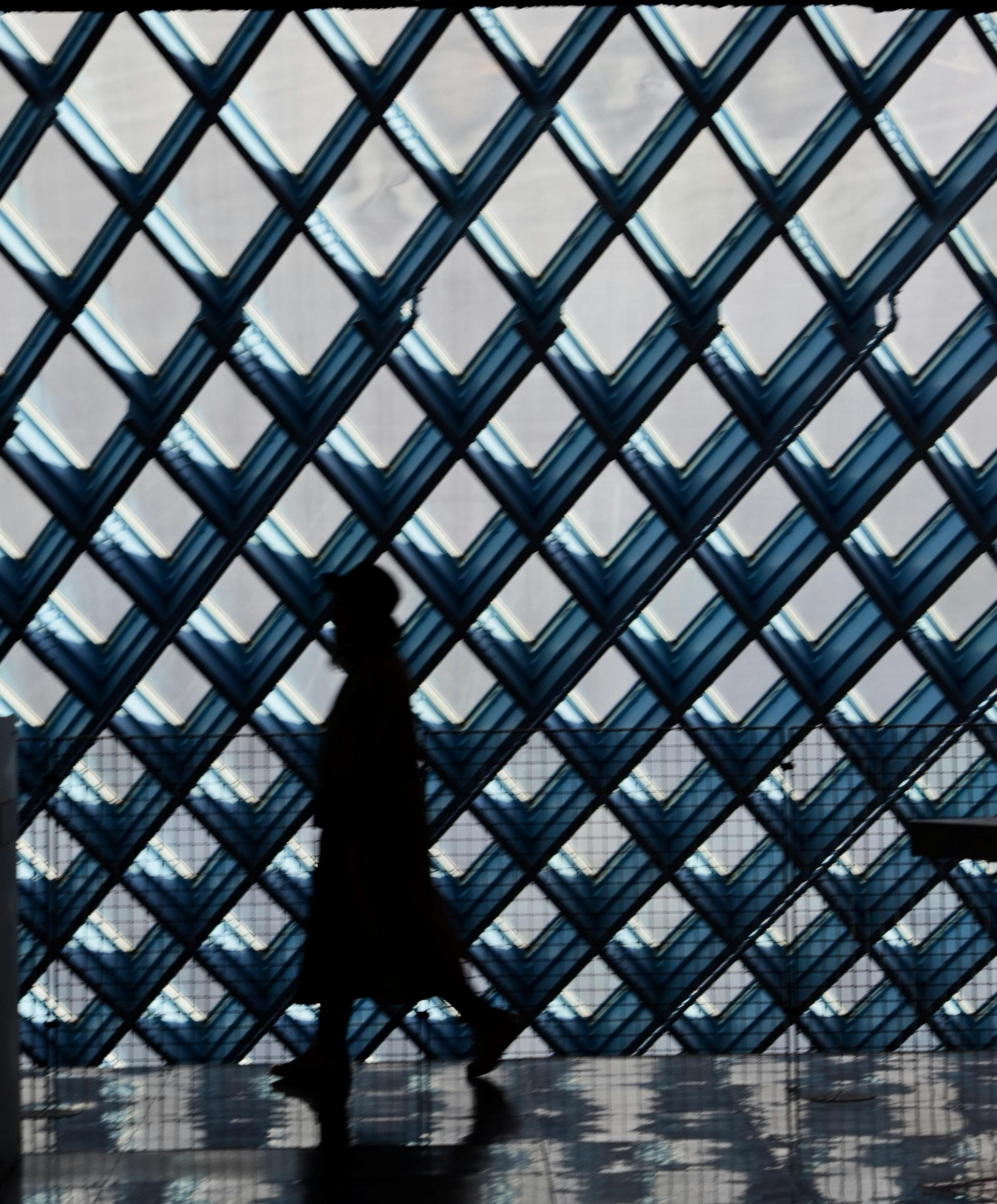 一个人走进西雅图未来派公共图书馆的剪影，呈现出独特的几何图案