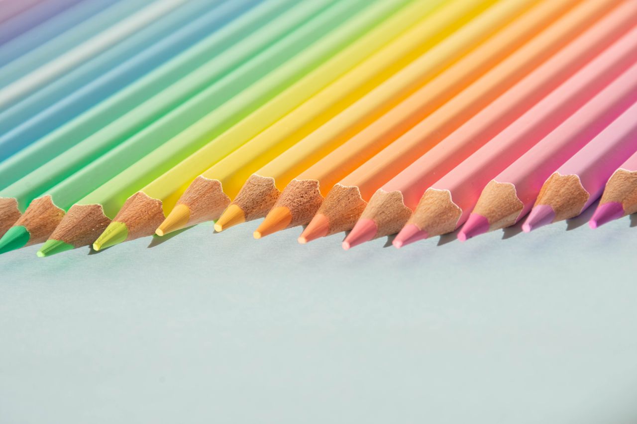 a close up of colorful pencils arranged neatly showcasing a rainbow gr