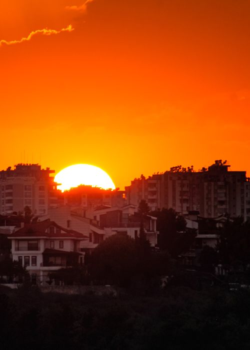 Free Dramatic urban sunset with silhouetted buildings against an orange sky. Stock Photo