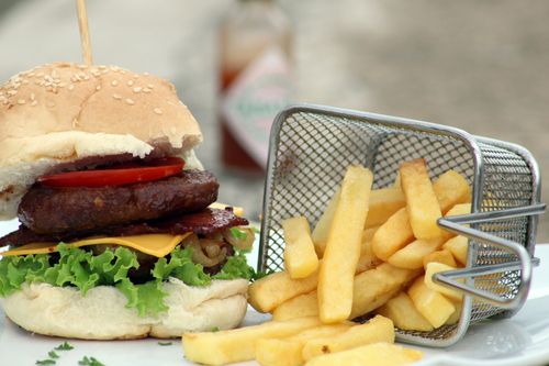 Free Delicious gourmet burger with crispy fries in a basket, perfect for satisfying cravings. Stock Photo