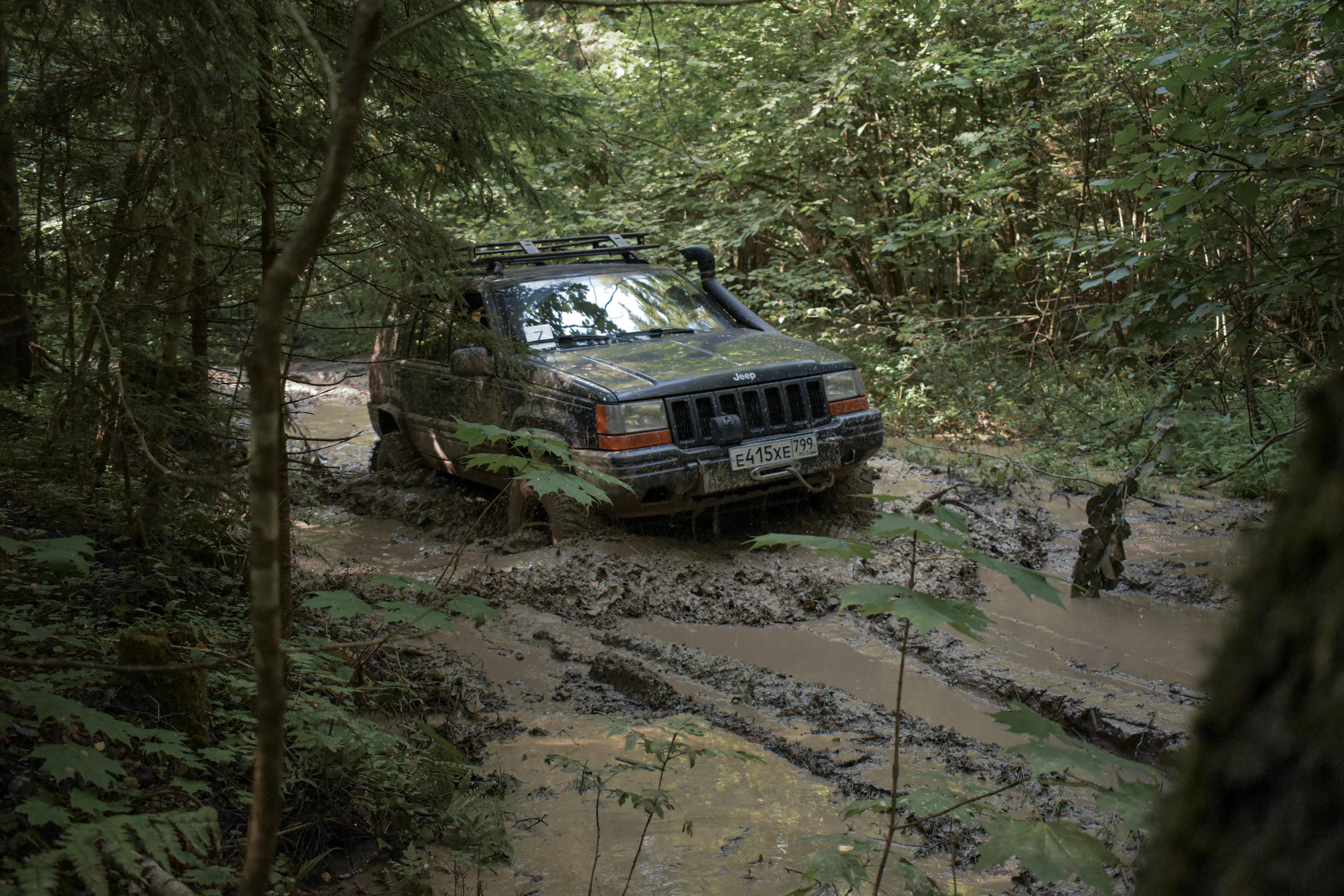 Experience a rugged off-road journey through a challenging muddy forest trail in Russia.