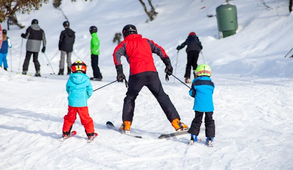 A group enjoying skiing lessons on a snow-covered mountain under clear skies.
