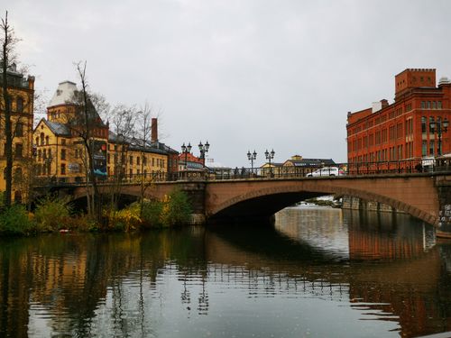 Free A scenic view of a historic bridge and old town buildings reflecting in the river. Stock Photo