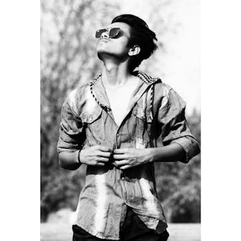 一位时尚的年轻人在户外戴着太阳镜仰望的黑白肖像