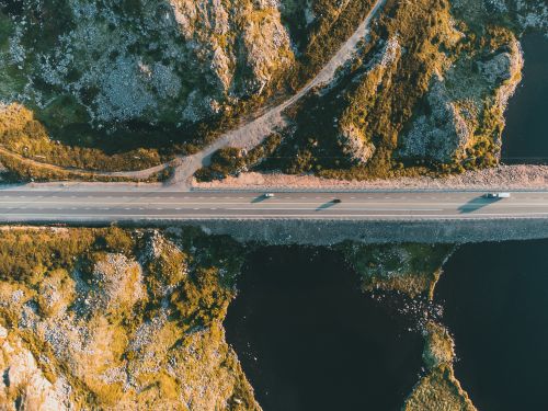 Free Aerial shot capturing a picturesque mountain roadway surrounded by rugged terrain and water. Stock Photo