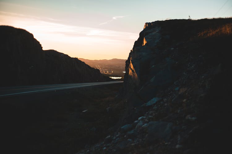 Silhouette Of A Road Between Rocky Hills At Sunset 