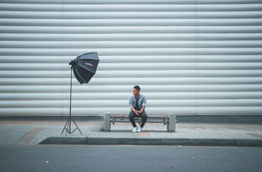 Man in Denim Shirt Sitting on Bench