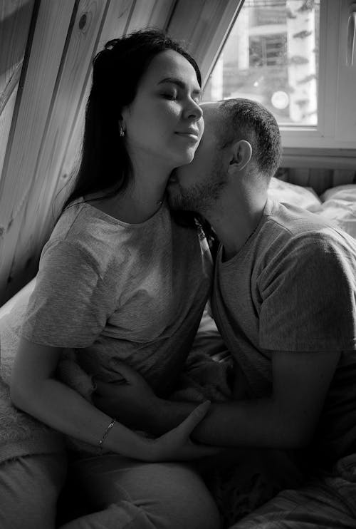 Grayscale Photo of a Man Kissing a Woman on the Neck