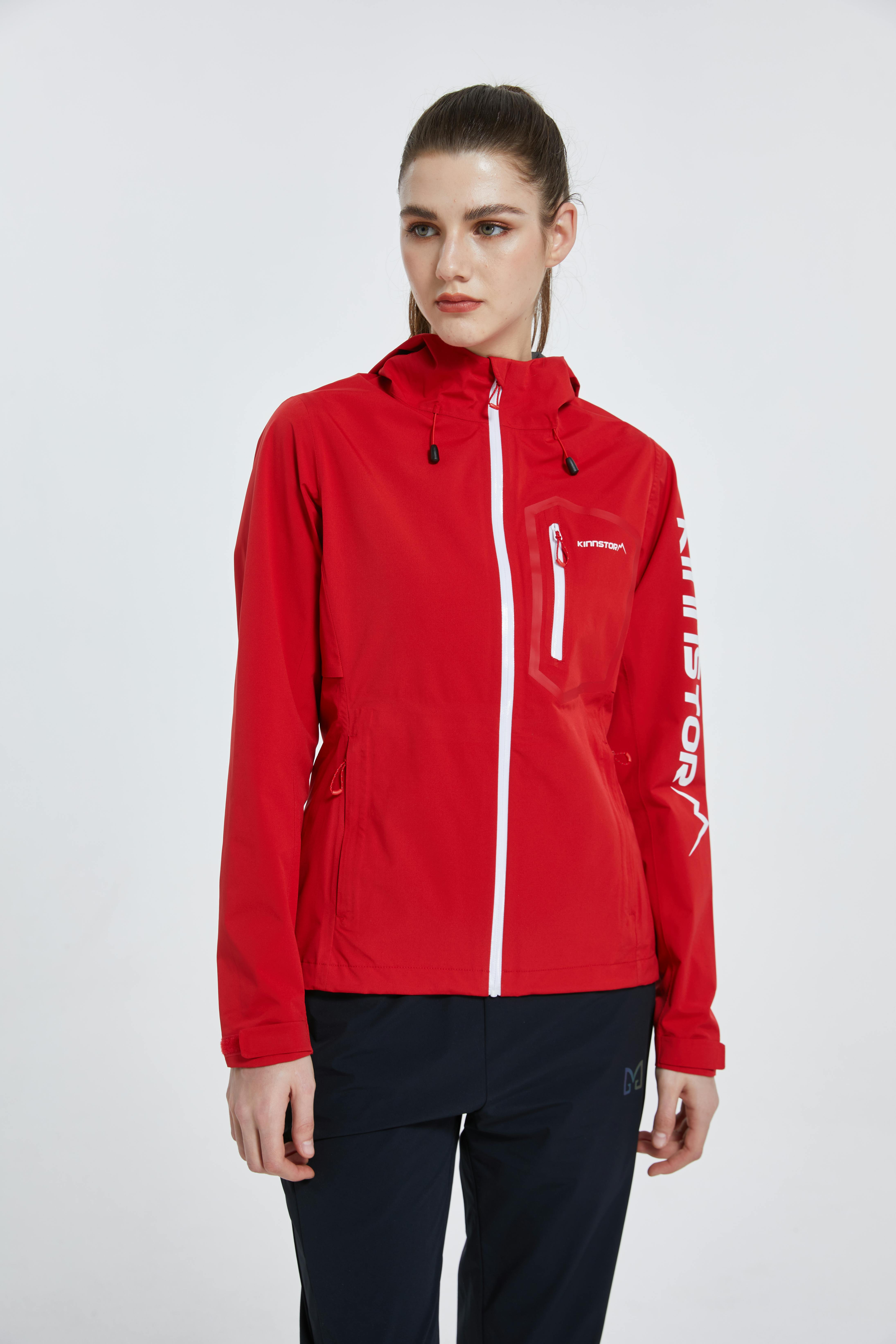 Free Stylish woman modeling a red jacket against a white background. Stock Photo