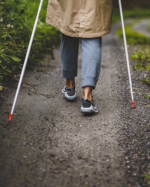 Back View of a Person Walking with Trekking Poles