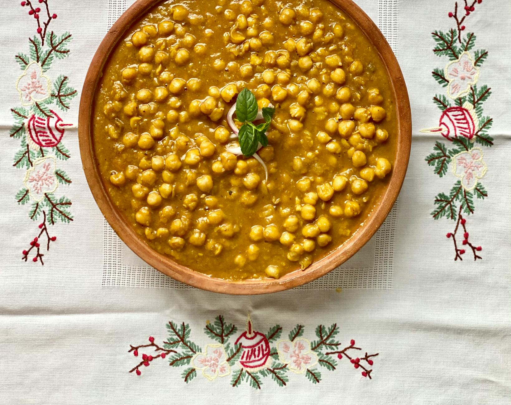 Delicious chana masala placed on a decorative embroidered cloth, showcasing traditional Indian cuisine.