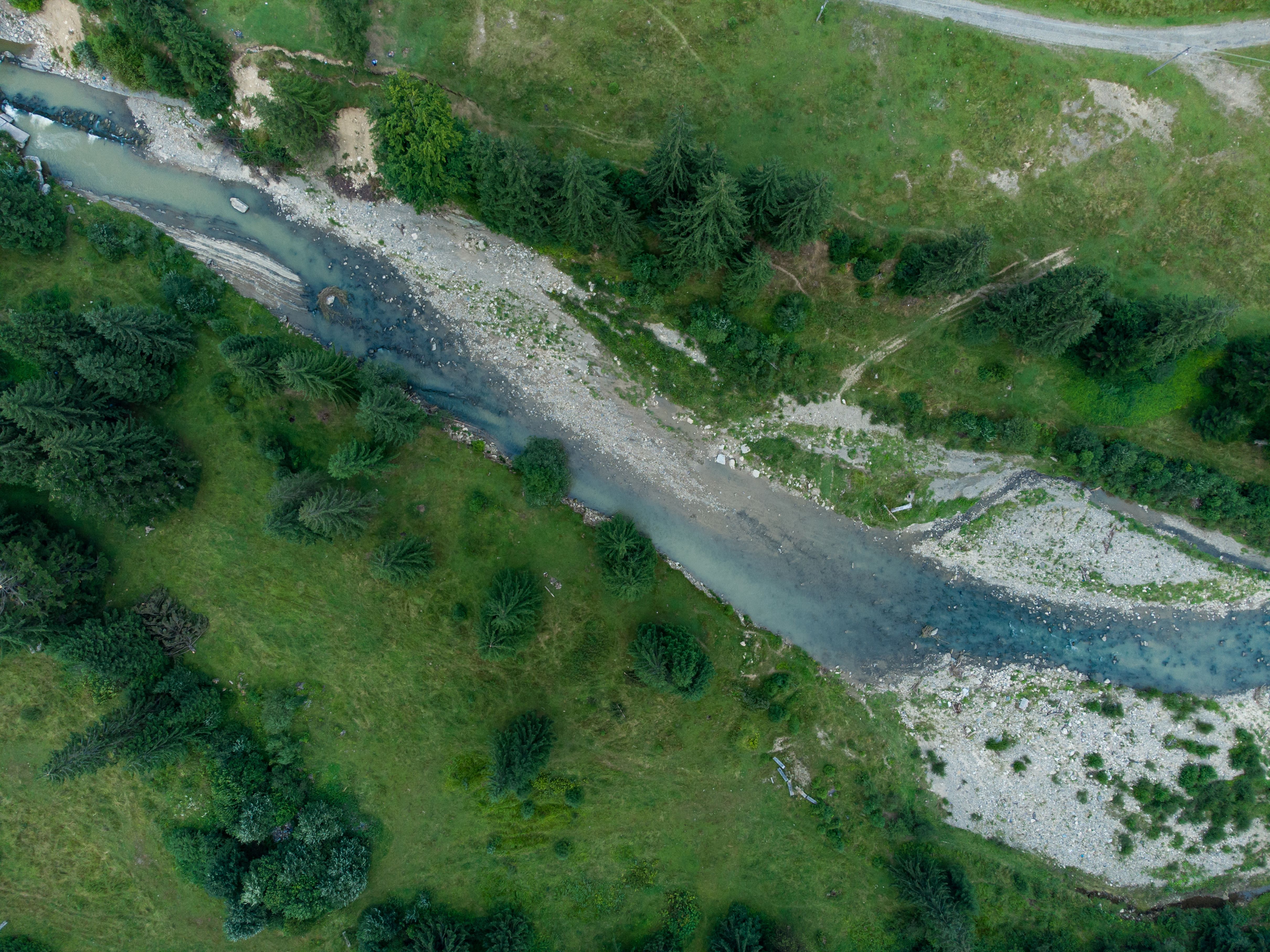Flusslauf zwischen bewaldeten Hügeln