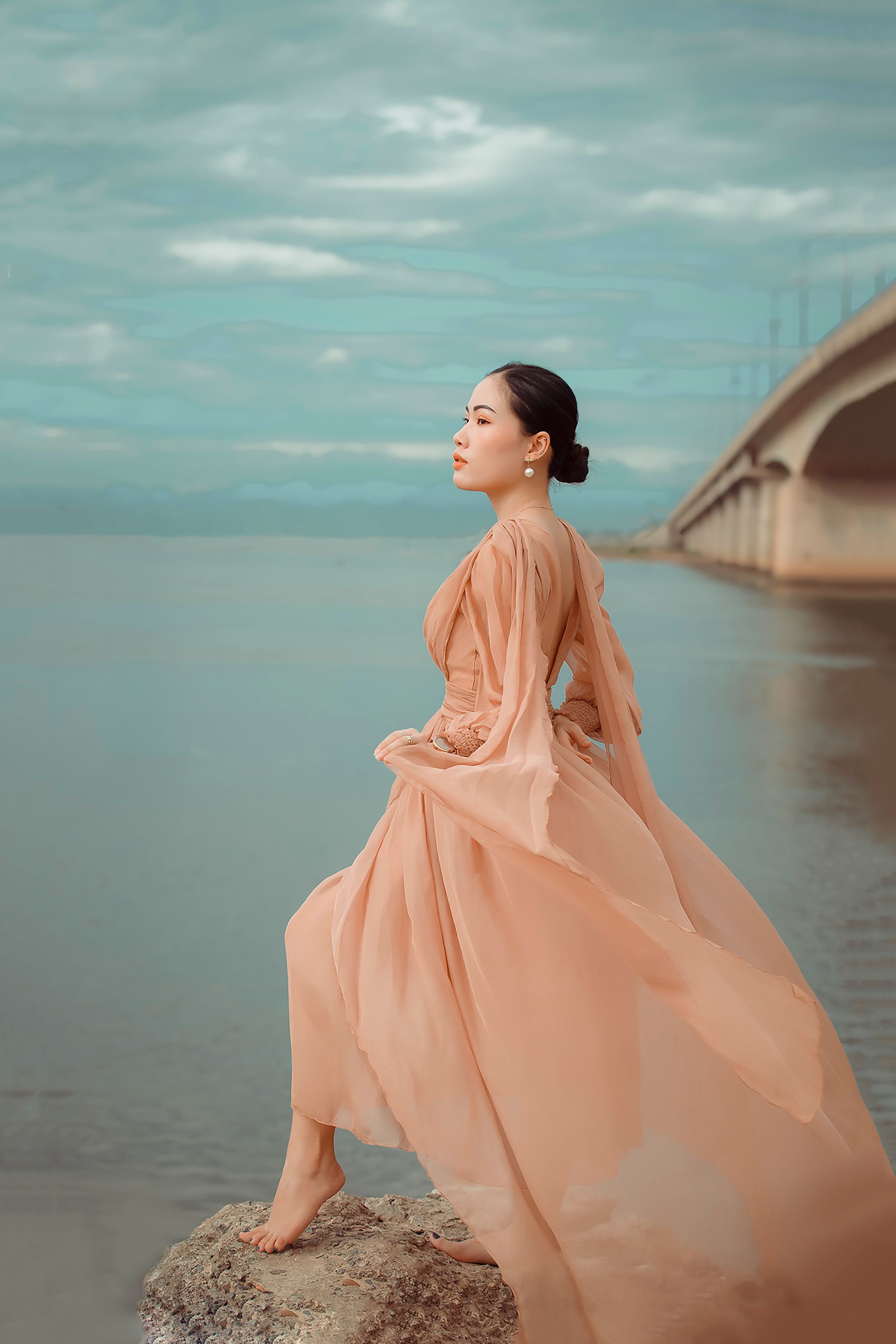 Woman in Beige Dress Standing on a Rock by the Sea · Free Stock Photo