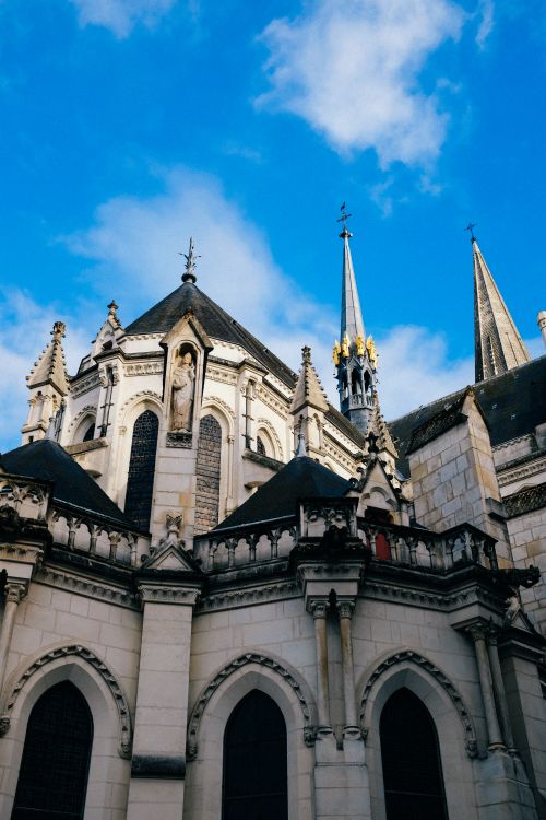 Free A majestic gothic cathedral tower under a clear blue sky, showcasing detailed architecture. Stock Photo