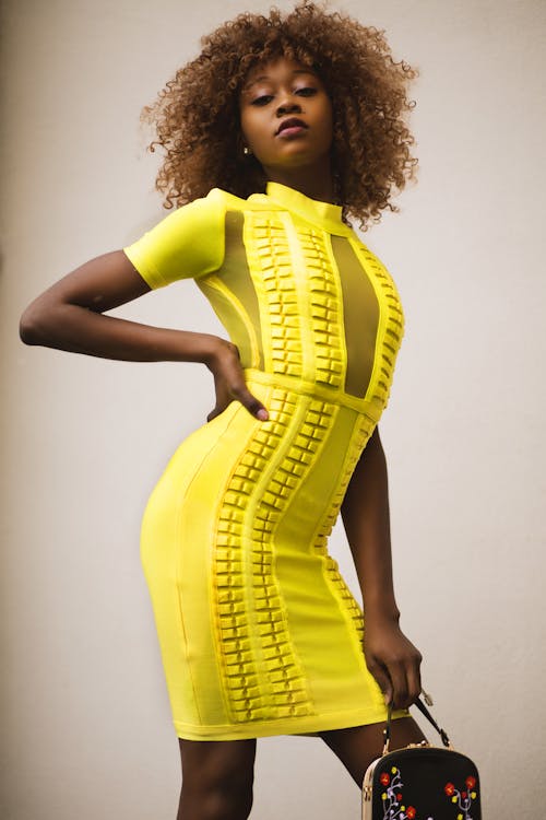 무료 노란색 Bodycon 드레스에 곱슬 머리 여자 스톡 사진