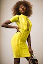 这位自信的女士身穿时尚的黄色连衣裙，展现了现代时尚与风格