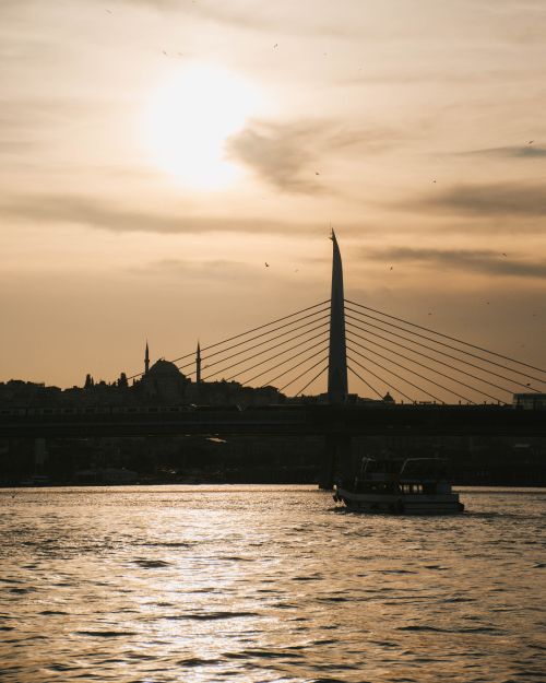Free Captivating sunset view over Istanbul's Golden Horn featuring a bridge silhouette and tranquil water reflections. Stock Photo