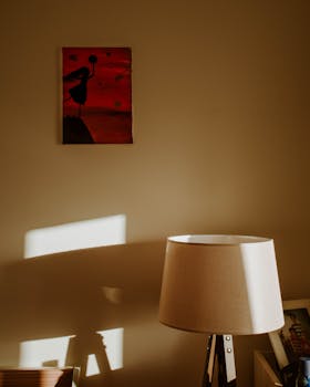 Warm-toned home interior featuring a stylish lamp and red artwork on the wall.