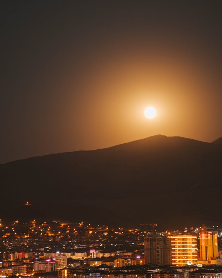 A Full Moon Over A Cityscape