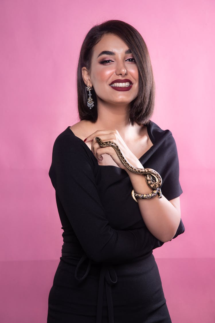 Beautiful Woman In Black Dress With Snake On Arm