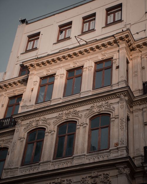 Free Close-up of a historic building facade showcasing intricate architectural details and elegant windows. Stock Photo