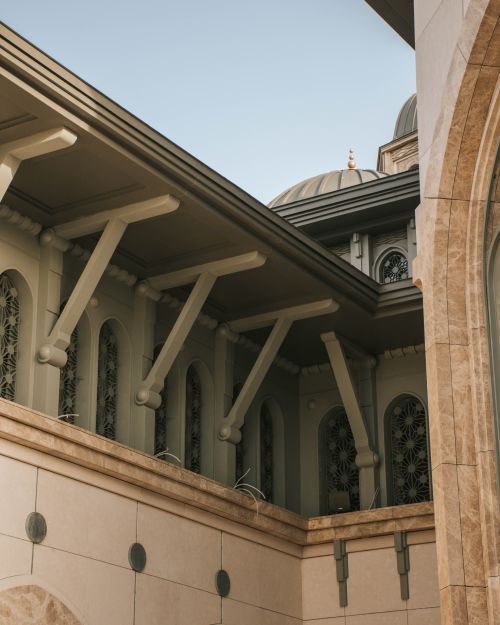 Free Beautiful architectural detail of a modern mosque with intricate patterns and arches. Stock Photo