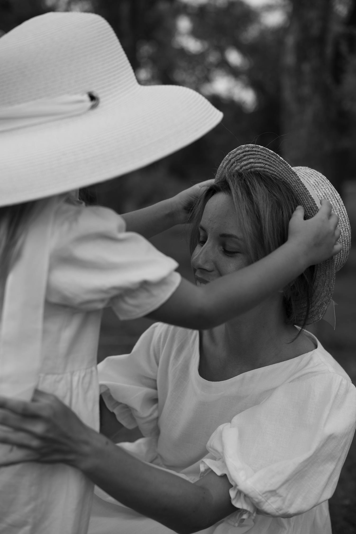 Photo of a Daughter Putting Hat on Her Mother's Head