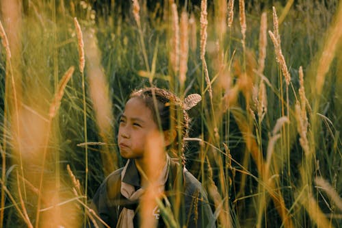 A Girl Scout Standing on a High Grass Field 