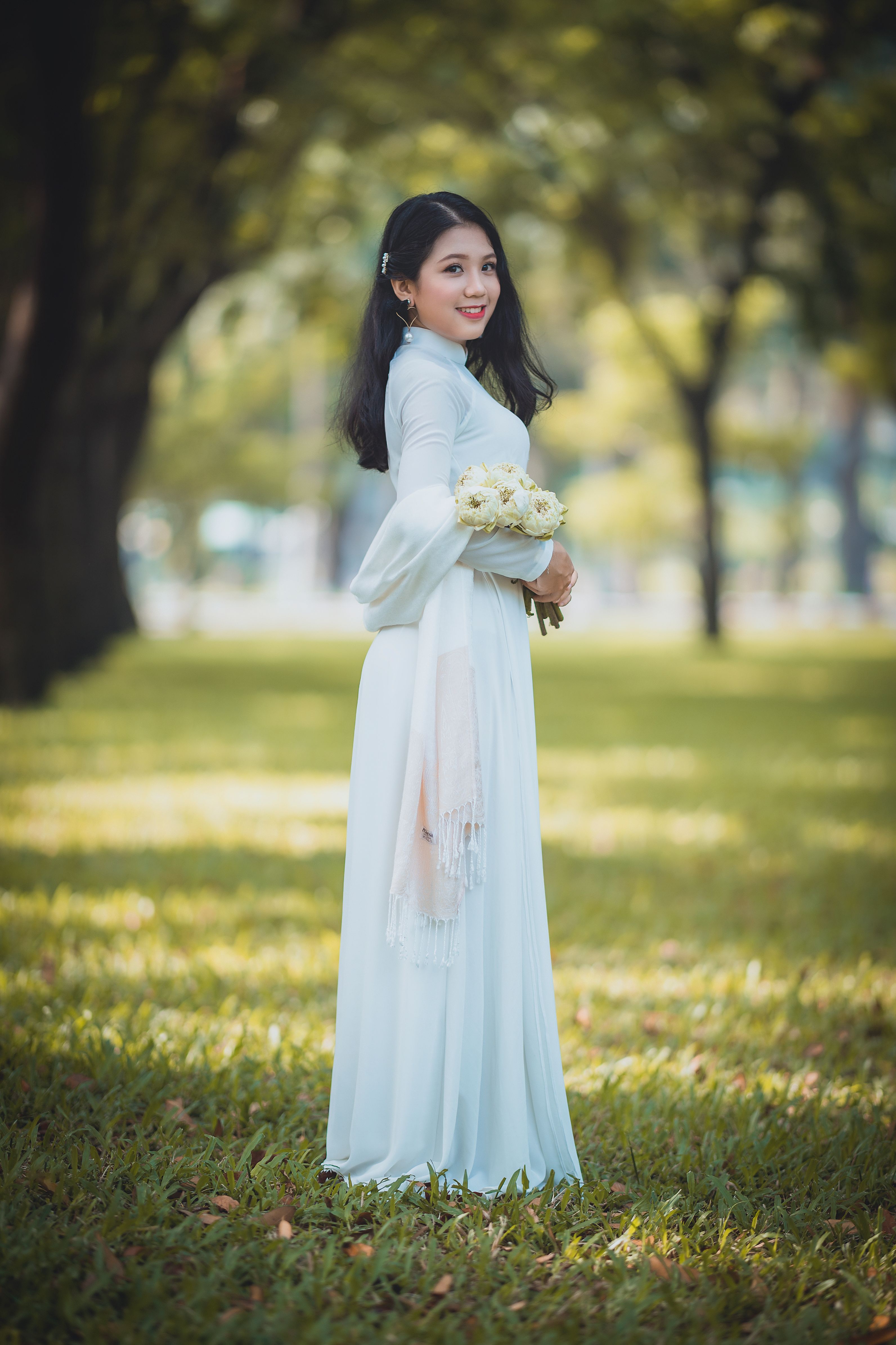 Beautiful Woman in White Dress Standing on Green Grass  Free Stock Photo