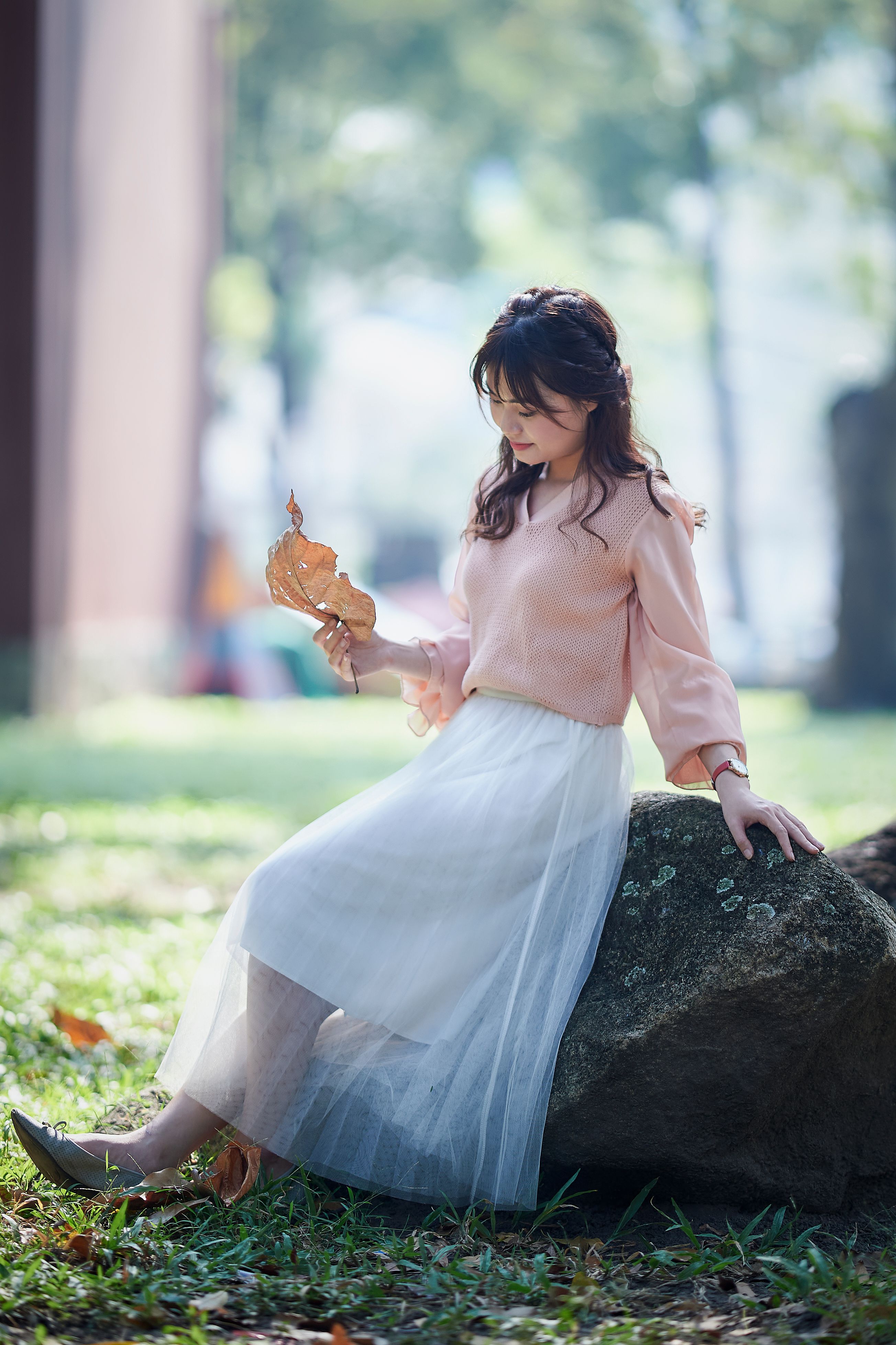 Woman in Pink Top and White Skirt Sitting on a Rock · Free Stock Photo