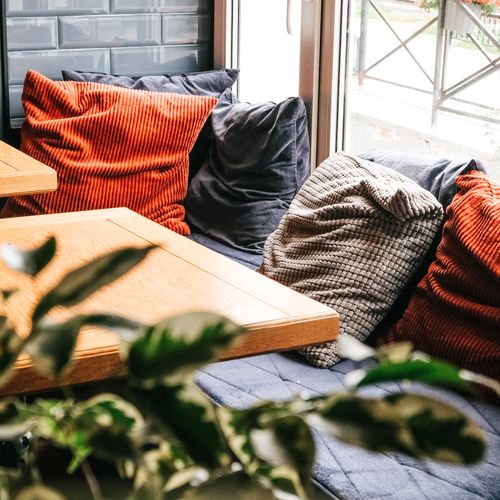 Corduroy and velvet cushions on a window seat — photo by Alexandra Kollstrem on Pexels