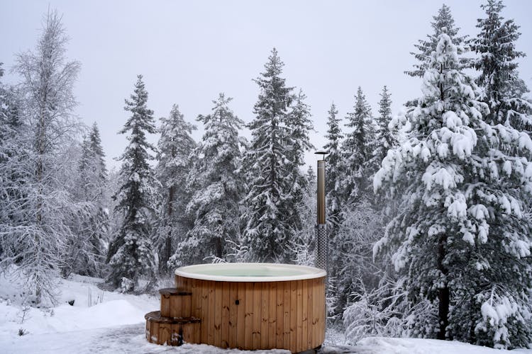 A Brown Wooden Jacuzzi On Snow Covered Ground During Winter