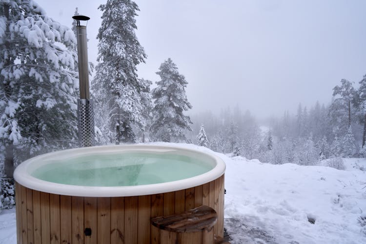 A Brown Wooden Jacuzzi On Snow Covered Ground During Winter
