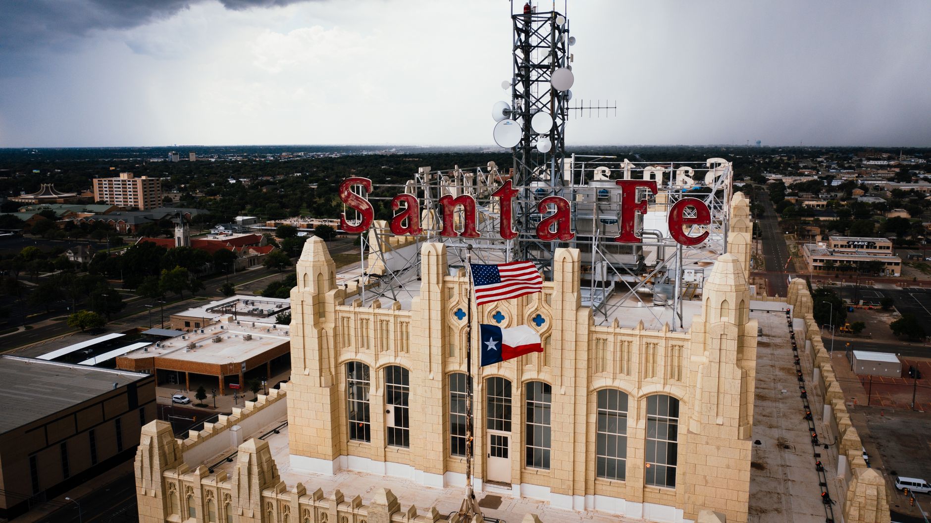 Aerial view of Santa Fe Building in Amarillo, Texas with US and Texas flags displayed prominently.