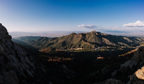 A Brown and Green Mountain Under Blue Sky