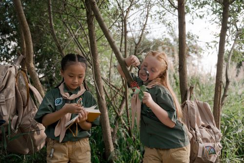 Free Two young girls engage in nature exploration during an outdoor scouting camp. Stock Photo