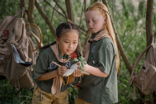 2 Girls Holding White and Red Flowers