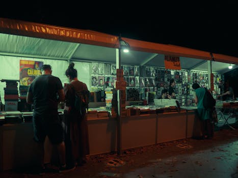 Discover a vibrant nighttime book market in İstanbul, bustling with avid readers and colorful stalls.