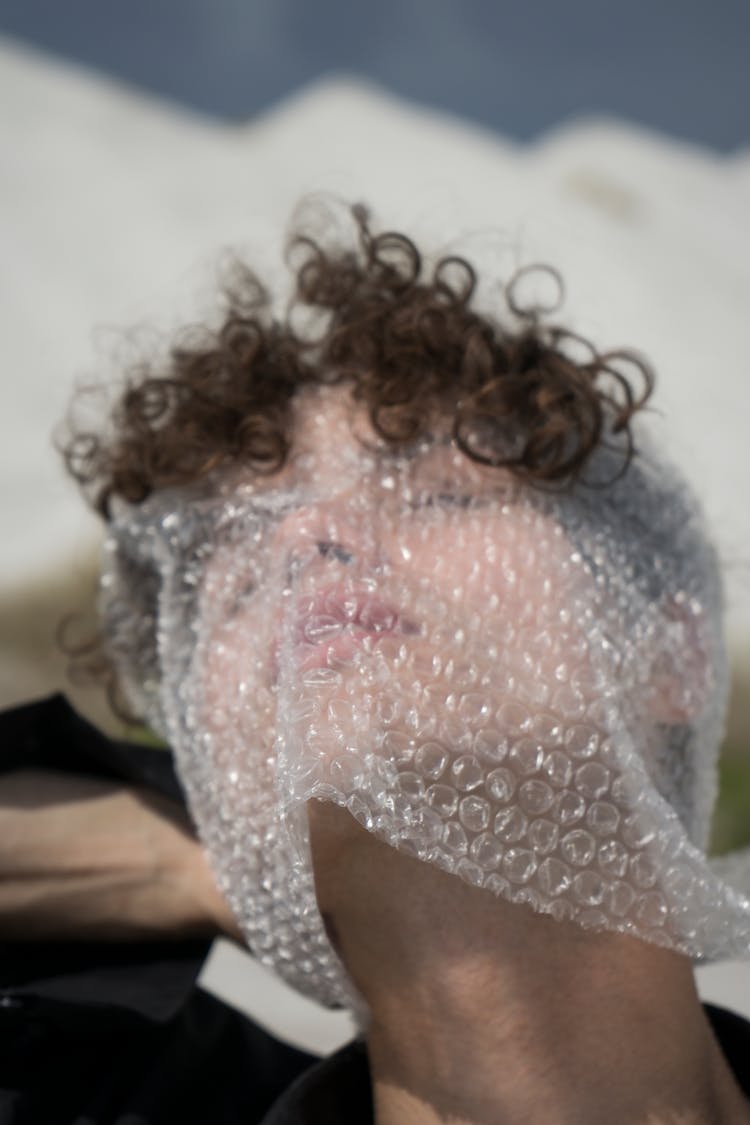 A Person Wrapping His Face With A Bubble Wrap