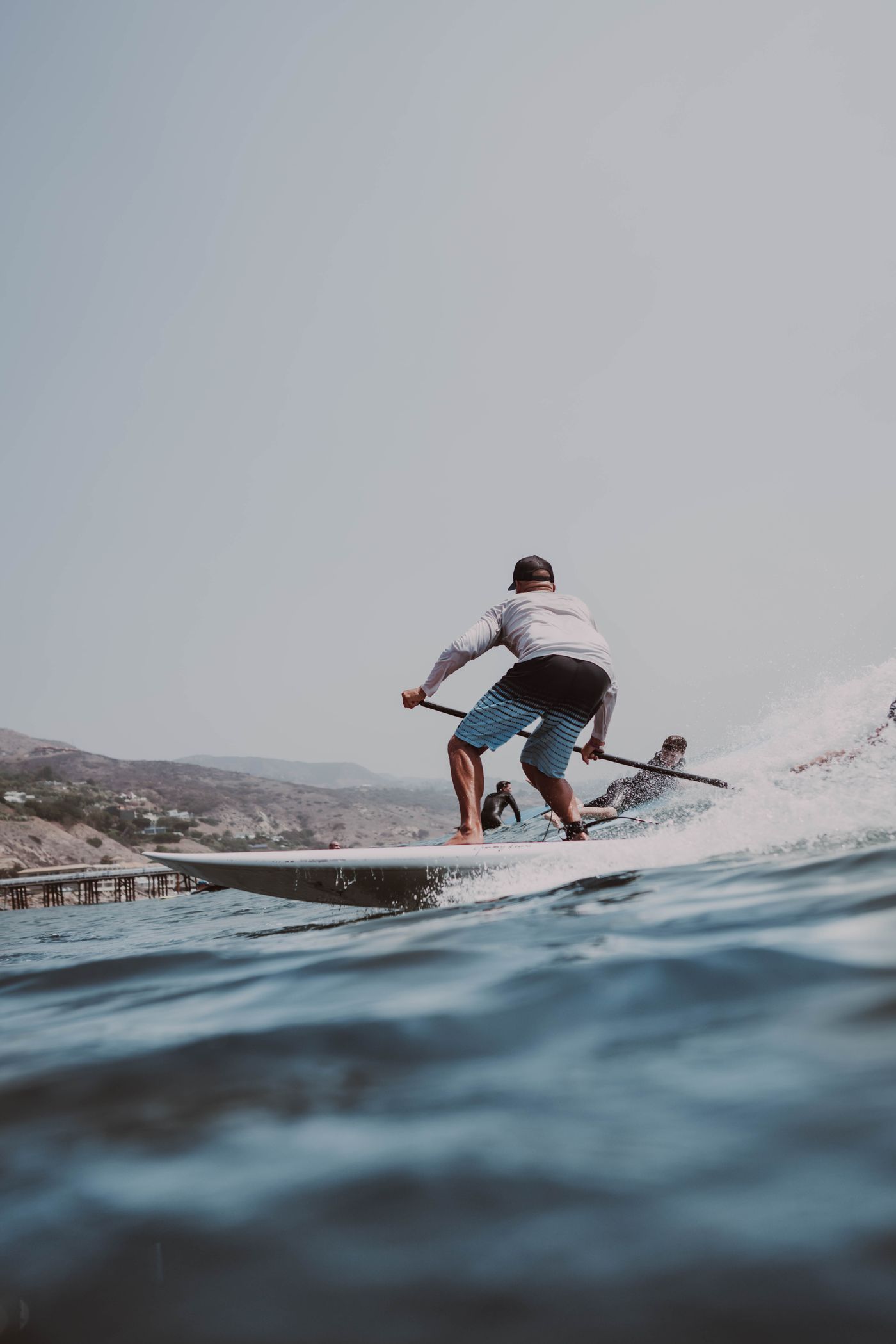 Paddleboarder standing on open blue water
