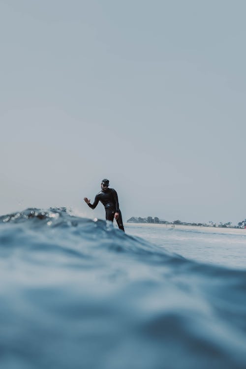 Person in a Black Wetsuit Surfing