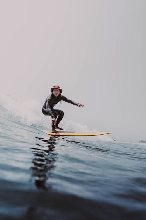 A Man in a Wetsuit Surfing 