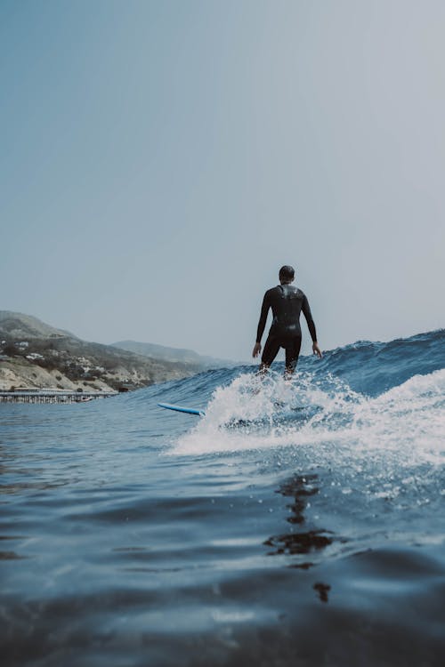 Back View of a Person Surfing on a Sea Wave