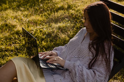 Free Woman in White Knit Sweater Using Black Laptop Computer Stock Photo