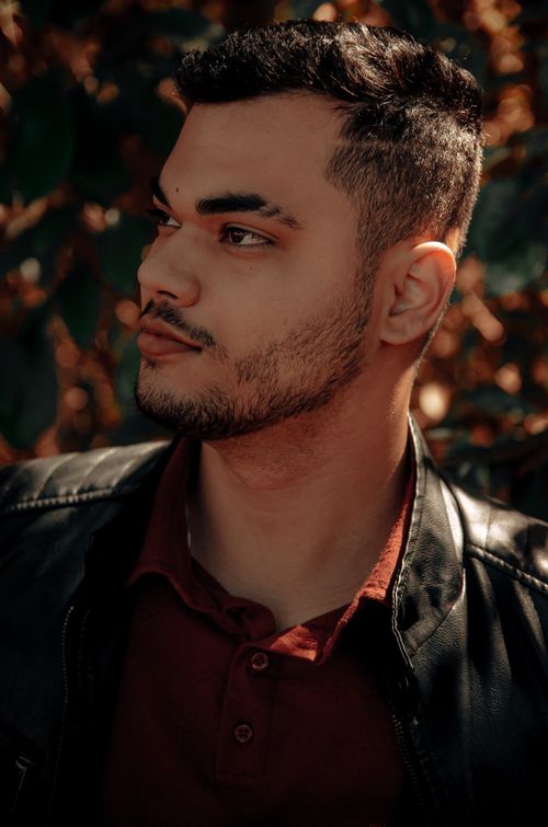 Free Portrait of a young man in a leather jacket against a blurred natural background. Stock Photo
