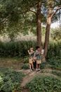 Boys Standing on Grass Field Near Brown Tree
