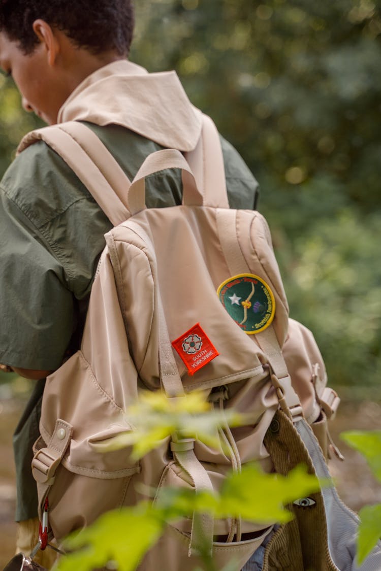 A Boy In Beige Backpack With Patches