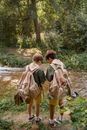 Back View of Two Boy Scouts Carrying a Backpack near the River