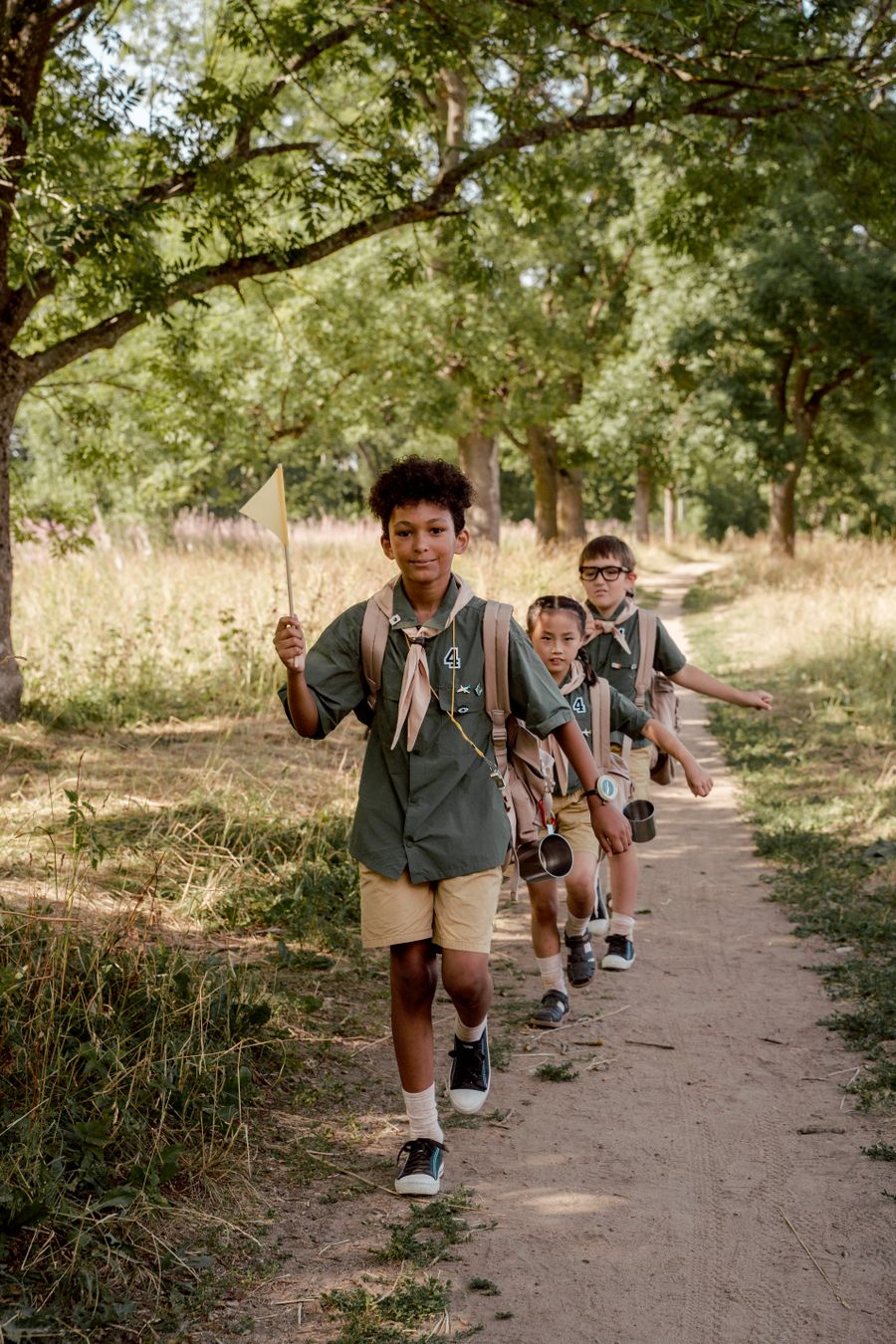 Campers hiking a shaded trail during a Camp Cypress nature day
